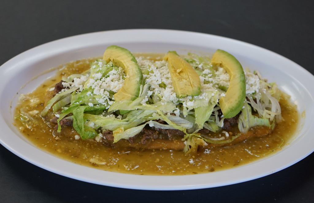Super Huarache · Fried Masa stuffed with Beans—topped with Tomatillo Salsa, Meat of your choice, Lettuce, Queso Fresco, Sour Cream, & Avocado