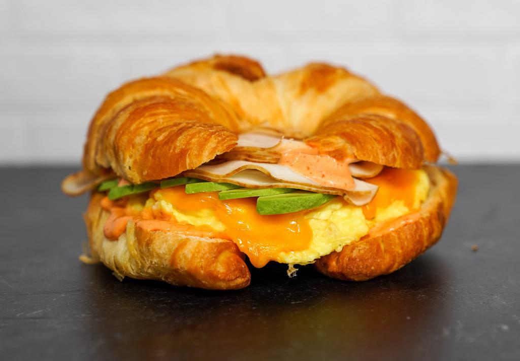 Croissant, Smoked Turkey, Avocado, Egg, & Cheddar Sandwich via Egg