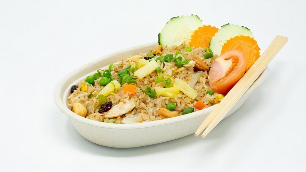 Pineapple Fried Rice · Stir-fried rice with scallions, tomatoes, carrots, raisins, and cashew nuts, pineapples and egg.