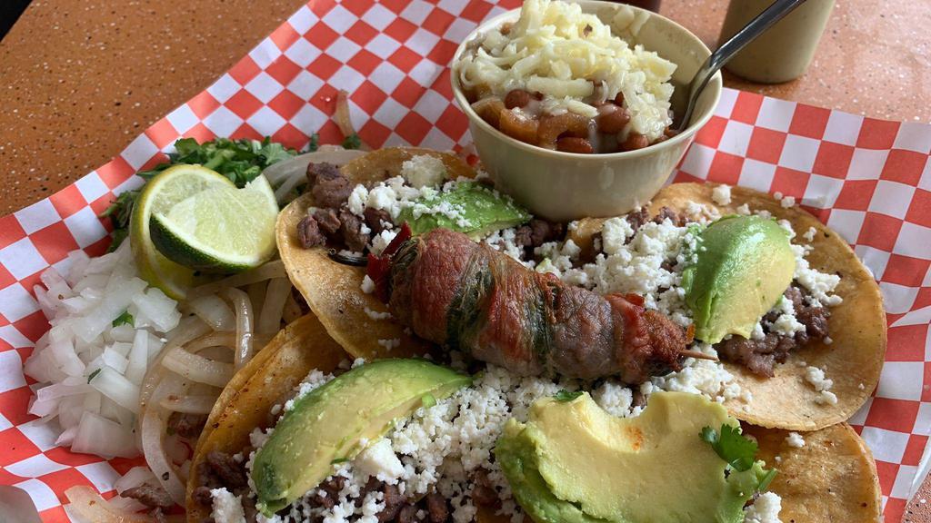 Tacos Matamoros · Four sirloin tacos with sliced avocado and queso fresco, served on corn tortilla, includes a bacon wrapped jalapeño, onions, cilantro, grilled onions and borracho beans with Monterrey cheese.
