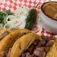 Mini Tacos Asada · Four mini tacos on homemade corn tortillas, served with onions, cilantro, grilled onions, li...