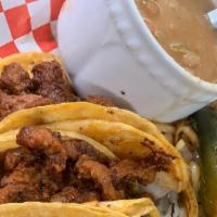 Mini Tacos Pastor · Four mini tacos on homemade corn tortillas, served with onions, cilantro, grilled onions, li...