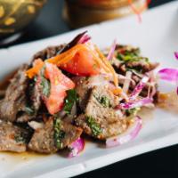Beef / Yum Nua Salad
 · Beef mixed with tomatoes, onions, lemongrass, and green onion in spicy lime sauce served on ...