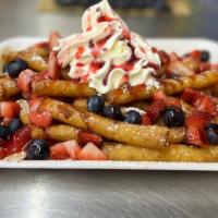 Very Berry Funnel Cake Fries · Our Funnel Cake Fries, covered in powdered sugar, topped with fresh cut strawberries and blu...