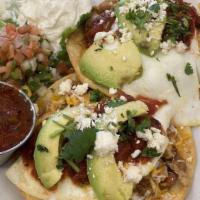 Huevos Rancheros · New. Pulled pork, cheddar cheese, two eggs, topped with our salsa, cilantro, feta, served wi...