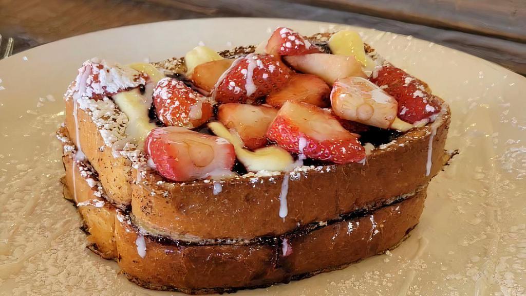 Stuffed Brioche French Toast · Two pieces, filled and topped with homemade creme fraiche, topped with fresh strawberries or blueberries and a blackberry sauce.