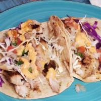 Asadero Fish Tacos (2) · Blackened tilapia cooked to perfection and topped with cabbage, creamy chipotle and lime cre...