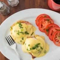 Eggs Benedict · English muffin topped with Canadian bacon, poached eggs and hollandaise.  Served with home f...