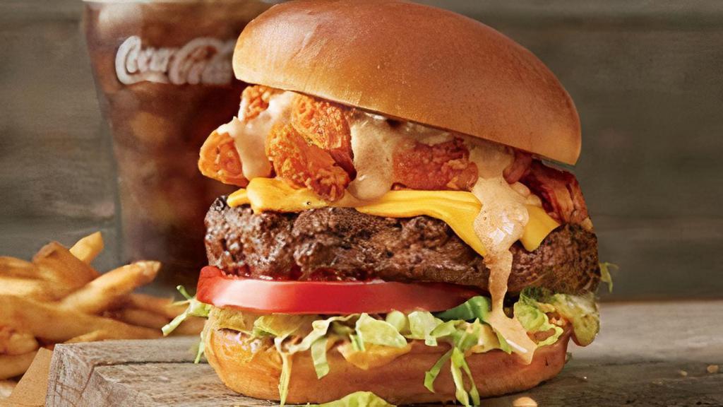 The Bloomin' Burger®* · Topped with Bloomin’ Onion® petals, American cheese, lettuce, tomato, house-made pickles, onion and our spicy signature bloom sauce. Served with one freshly made side.