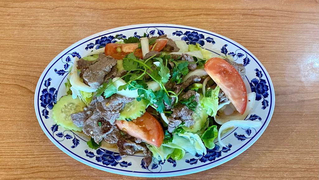 Crying Tiger (Beef Salad) · Beef tossed in lime dressing, peppers, garlic, cucumber, onions and tomatoes served over iceberg lettuce. Squid for an additional charge.