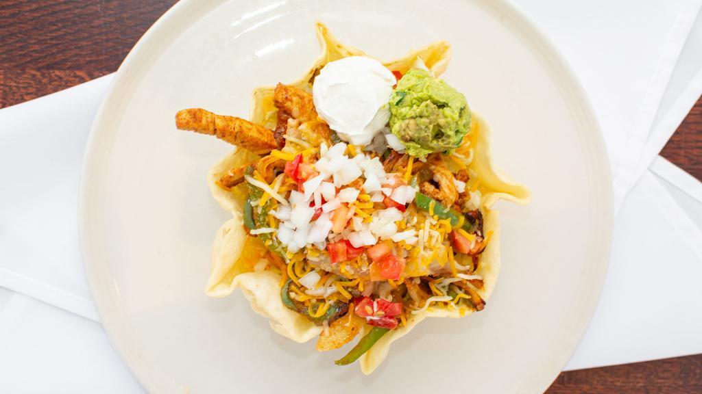 Deluxe Fajita Taco Salad · Our famous marinated meat sautéed with green peppers, onions, lettuce, cheese, tomatoes, onions, sour cream and guacamole.
