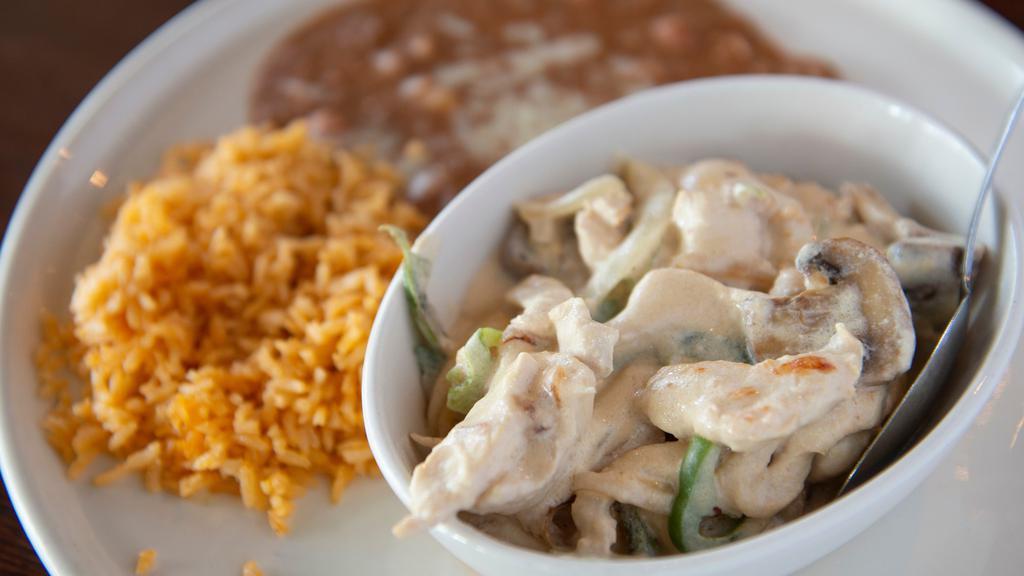 Pollo A La Crema · Strips of chicken breast sautéed in a special garlic cream sauce, peppers, mushrooms, rice, and beans.