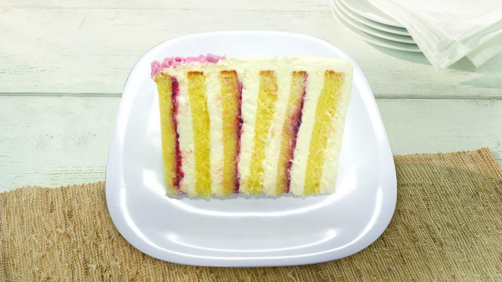 Colossal Lemon Raspberry Cake Slice · 6 layers of Cream Cake filled and frosted with Raspberry Spread & Lemon flavored Buttercream garnished with pink sprinkles.