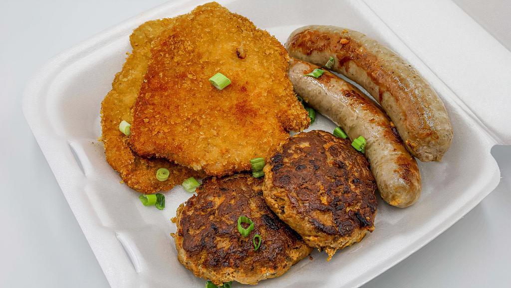 Sampler Plate · Includes 2 Schnitzels, 2 Sausages (choice), 2 Frikadelles, Sauerkraut, Spaetzle, Red Cabbage, Mashed Potatoes, a cucumber salad and brown gravy.