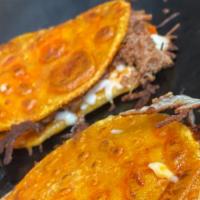 Mulita De Birria (Maiz) · Street style double sided tortillas with melted cheese, onion, cilantro .