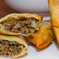 Beef & Feta Samosas · Hand wrapped pastry shells with seasoned ground beef and feta cheese. Served with mint and t...