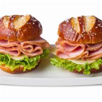 Ham & Swiss Pretzel Duo Sandwiches · Two pretzel buns each with sliced ham, mild Swiss cheese and leaf lettuce. Served with musta...