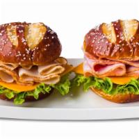 Ham & Turkey Pretzel Duo Sandwiches · One ham, cheddar and leaf lettuce and one turkey, cheddar and leaf lettuce pretzel bun sandw...