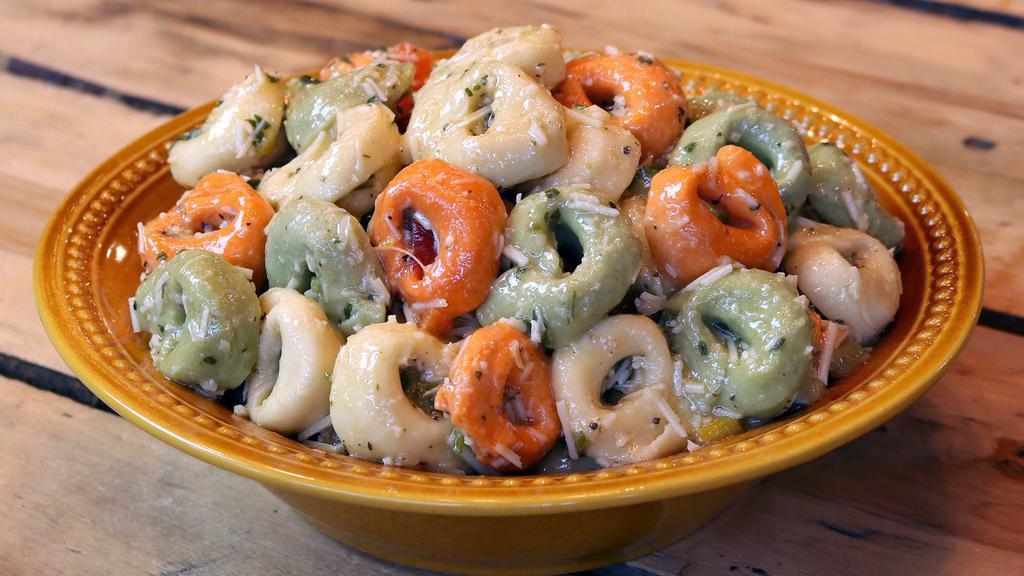 Cheese Tortellini Pasta Salad · Tri-color cheese tortellini, diced cucumbers, red and yellow bell peppers, and green onions mixed in a vinaigrette topped with fresh Parmesan cheese.