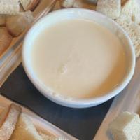 Fondue · Swiss, Asiago, and Parmesan melted together with white wine. Served with rustic bread for di...