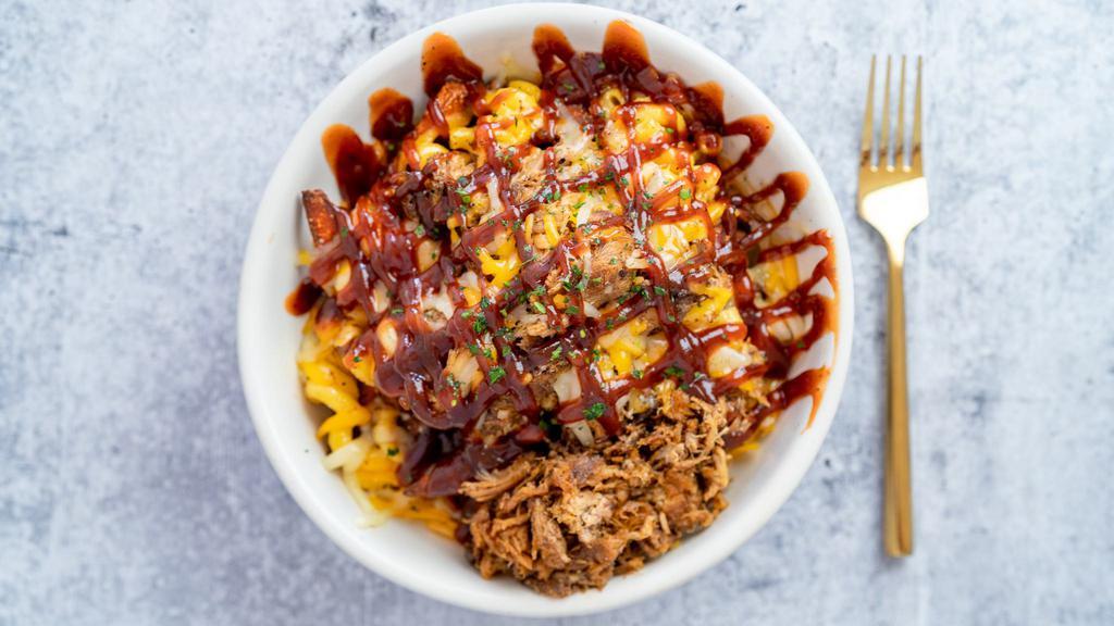 Sweet Piggy Mac Bowl · A delicious bowl of sweet potato fries smothered in ma and cheese and BBQ pulled pork.