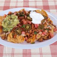 Nachos · With choice of meat, refried beans, black beans, tomato, jalapeno, sour cream, guacamole.