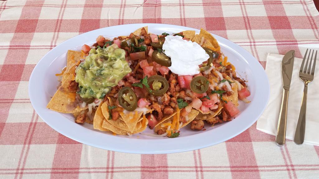 Nachos · With choice of meat, refried beans, black beans, tomato, jalapeno, sour cream, guacamole.