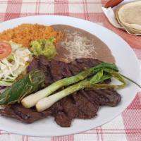 Carne Asada · Broiled skirt steak. Served with rice, beans, salad, guacamole, green online, jalapeno peppe...