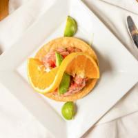 Ceviche Tostada · A crispy, flat corn tortilla topped with cold shrimp salad, avocado and an orange slice.