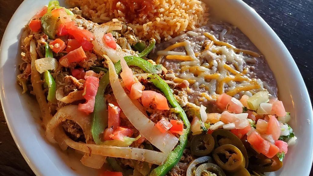 Machaca & Eggs · Three eggs scrambled with shredded beef, bell peppers, onions, and tomatoes. Garnished with pico de gallo and jalapeños. Served with tortillas, rice and beans.