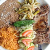 Carne Asada · Lean grilled inside skirt steak. Served with avocado nopales, onions, fried chiles, and tort...