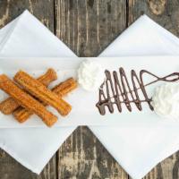 Churros · Fried dough pastry dusted in a mix of sugar cinnamon and chocolate