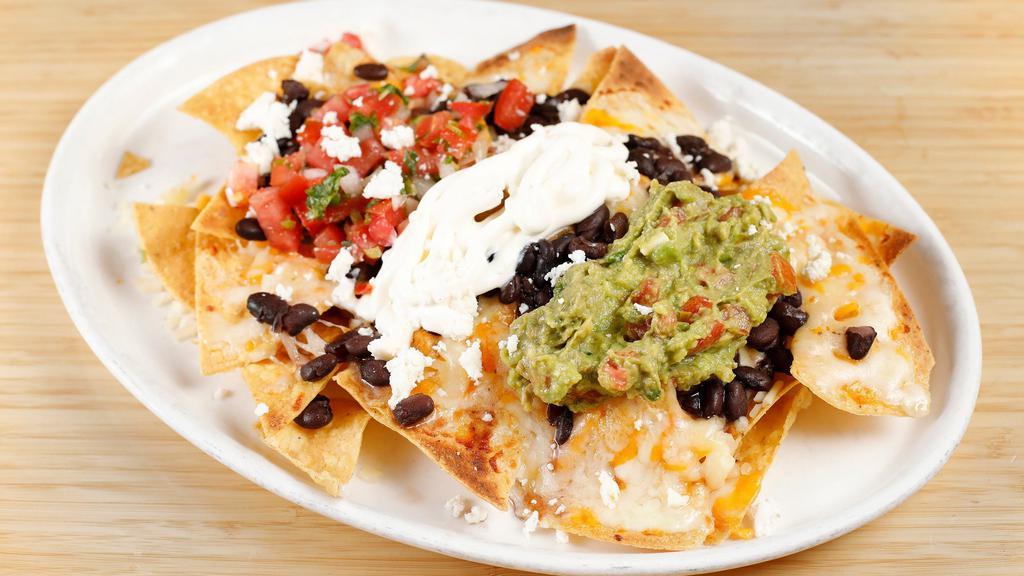 Nachos · Refried beans, pico de gallo, jalapeños, guacamole, sour cream, melted cheese, and your choice of meat over crispy tortilla chips.