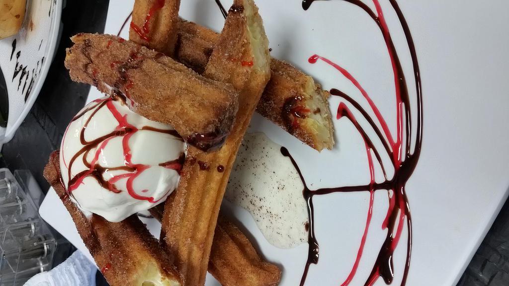 Churros · Crispy churros filled with cream coated on cinnamon sugar, chocolate sauce and served with vanilla ice cream.