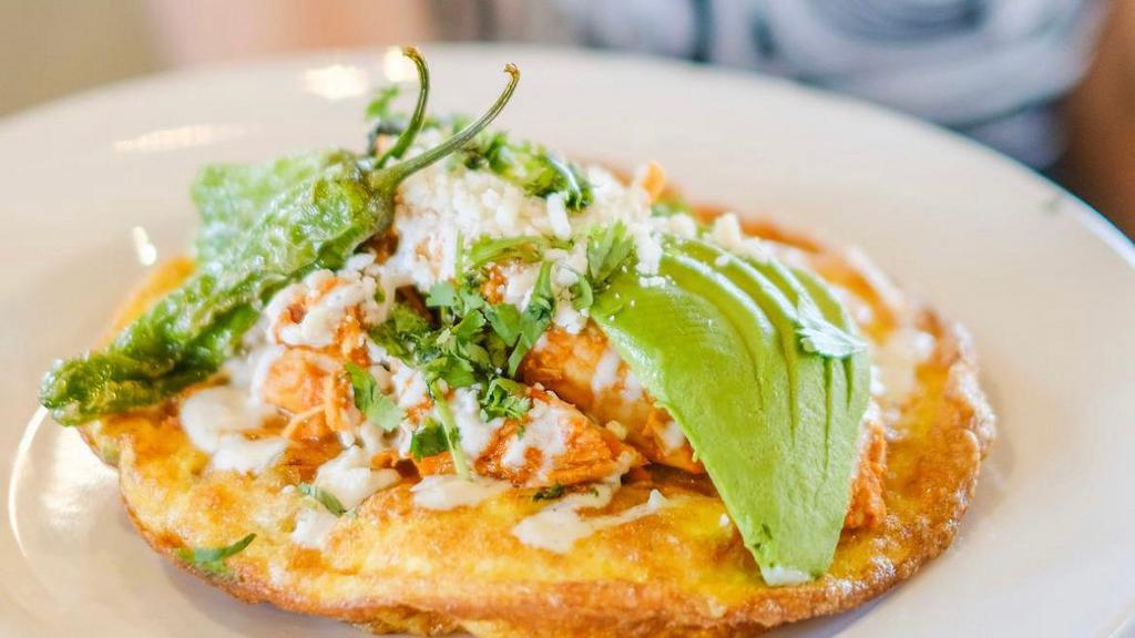 Chicken Tinga Frittata · Chipotle-braised chicken breast, caramelized onions, blistered shishito peppers, queso fresco, avocado, crema, green chili salsa, tortillas, served with hash potatoes.