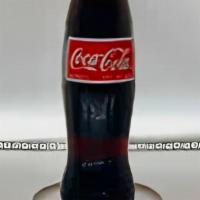 Mexican Coca Cola · 12 oz Glass Bottle of Mexican Coca Cola drinks. Mexican Coke is sweetened using cane sugar!
