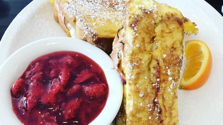 Monte Cristo · Texas toast, turkey, ham, Swiss and cheddar cheese dipped in egg batter and grilled to a golden brown served with strawberry compote and side of fruit.
