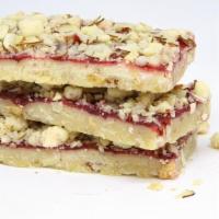 Rasberry Jammer Bar · Take a white chocolate shortbread base with crunchy almonds, add pure raspberry preserves an...