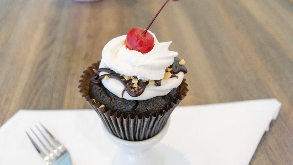 Hot Fudge Sundae Cupcake · Chocolate cake with our signature buttercream frosting, peanuts, whipped topping, hot fudge and a cherry on top.
