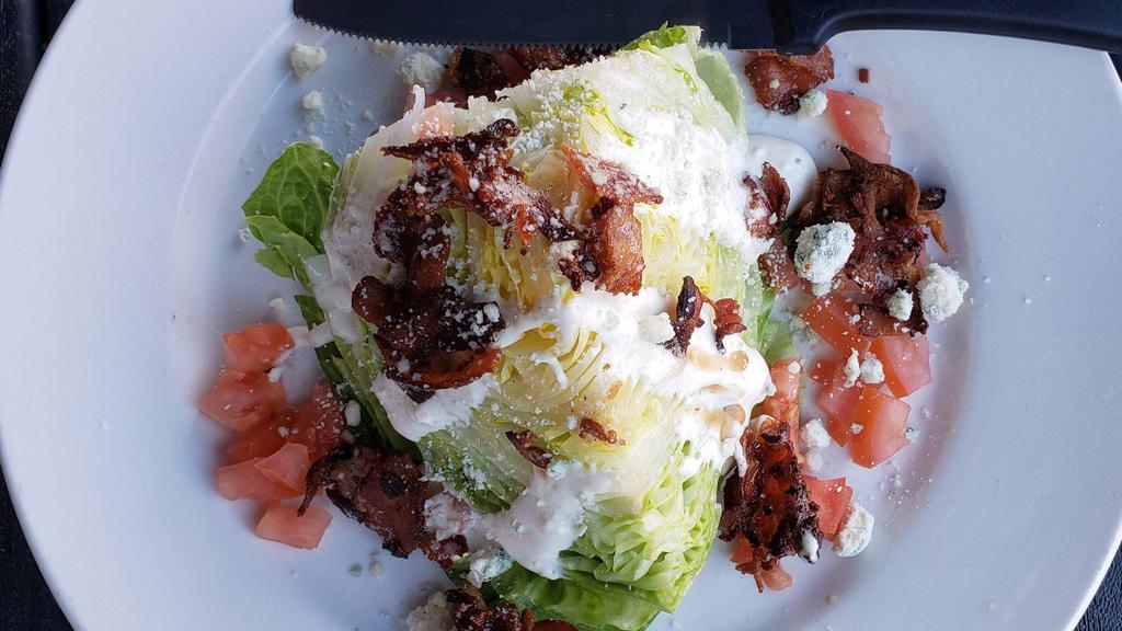 Wedge Salad · Classic wedge, 1/4 head of iceberg, blue cheese crumbles, diced tomatoes, bacon, blue cheese dressing.
