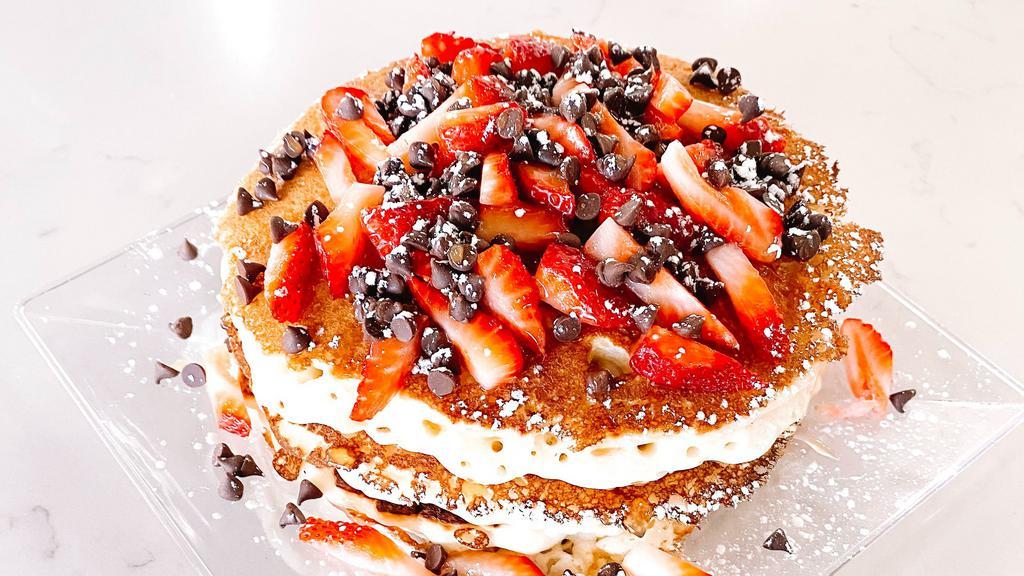 Strawberry Stack Pancakes · Daily Drip's three buttermilk pancakes served with fresh strawberries, chocolate chips, maple syrup, & powdered sugar