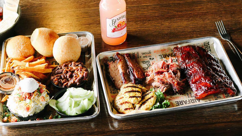 The Sampler · Feeds two-three adults. Can’t decide what to try? Don’t! The sampler includes: three smokehouse meats of your choice. Half rack of our ribs brushed with bbq sauce, four famous sides, three fresh rolls.