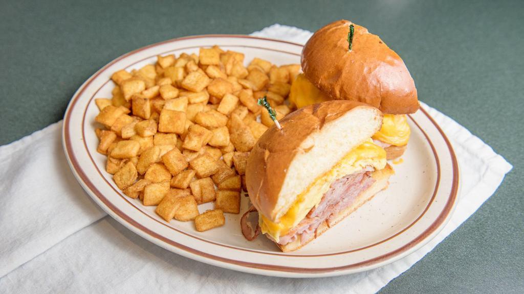 Eggworks Breakfast Sandwich · Grilled butter brioche bun with choice of sliced ham, sliced bacon, godshall's turkey bacon, or patty sausage. Two eggs over hard topped with your choice of cheese. Served with habla diablo seasoned potatoes.
