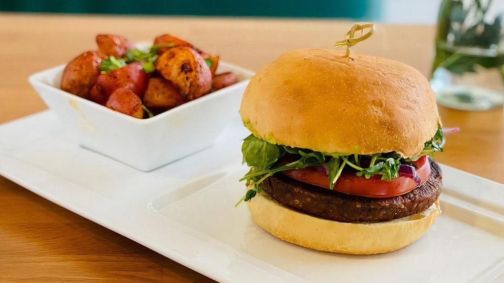 Sonoran Tepary Burger · sonoran style burger patty of tepary beans, organic, sustainable and locally grown. Baby arugula, hothouse tomato, sliced red onions, cilantro jalapeno hummus, brioche bun