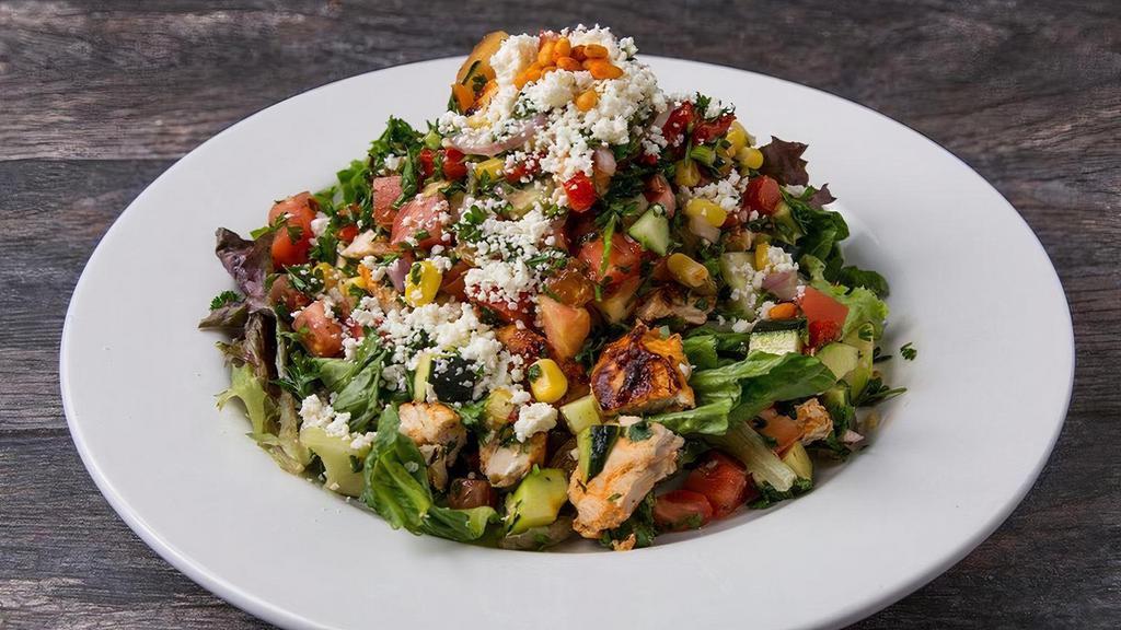 Mediterranean Chicken Salad · grilled chopped all-natural chicken breast, roasted bell peppers, cucumbers, taboule, seasonal mixed greens, corn, diced tomatoes, red onions, feta, golden raisins, toasted pine nuts, fresh cilantro, lemon vinaigrette