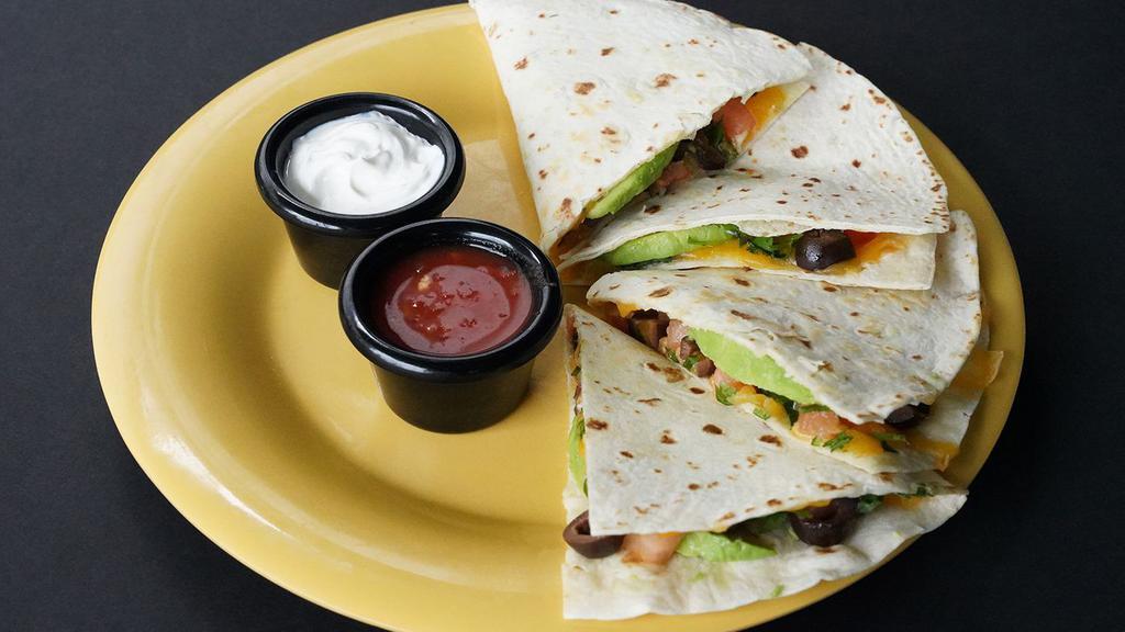 Deluxe Quesadilla · Cheddar Cheese · Diced Tomatoes · Olives · Sliced Avocado · Cilantro · Served with fresh mild red salsa and sour cream on the side.