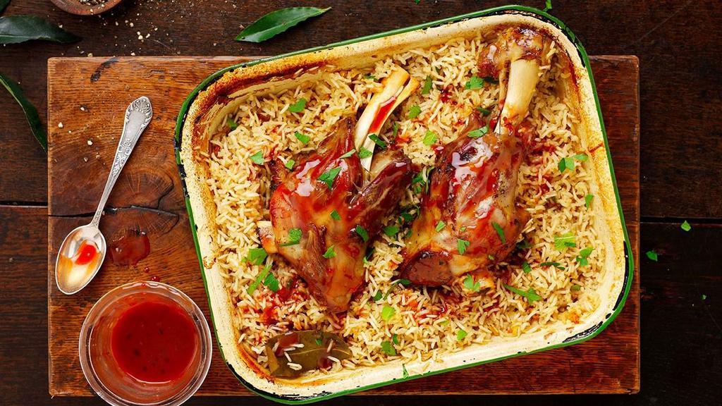 Lamb Shank Palow · Afghan style rice cooked with lamb, onions, garlic, ginger, and other spices served with eggplant burani and Afghan salad.