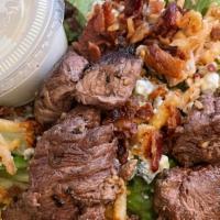 Steakhouse Salad · Medium-rare marinated steak served over mixed greens, tomato, chopped bacon, bleu cheese cru...