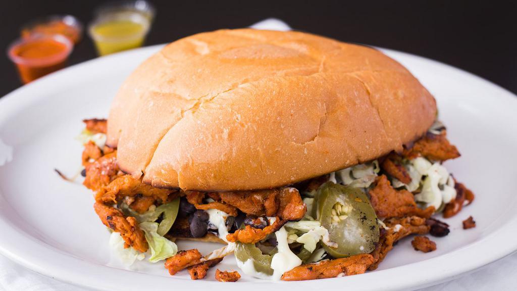 Torta · Mexican sandwich with choice of meat, butter, beans, mayonnaise, jalapeño, grilled onion, and lettuce.