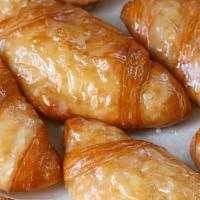 Glazed Croissants · Our flaky croissants dunked in a sweet glaze.